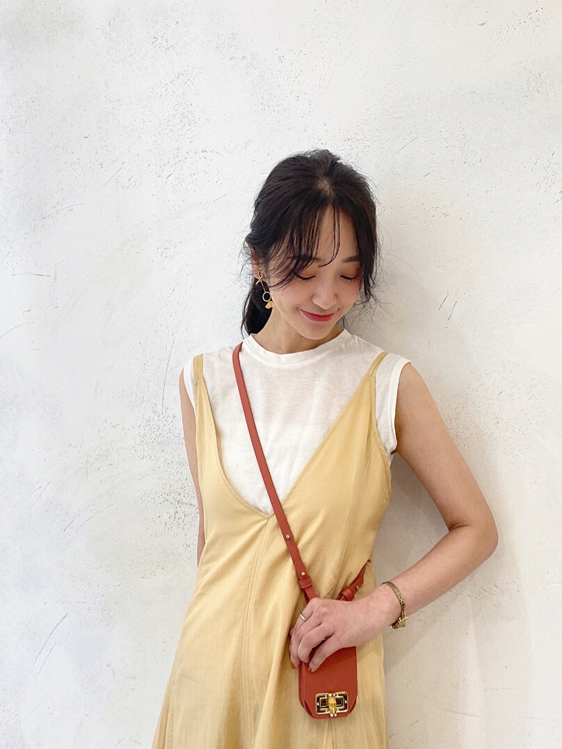 イエロー系のワンピース、ベージュ系のニット/セーター、ホワイト系のテーラードジャケットを着用したレディースの春コーディネートの6枚目の写真