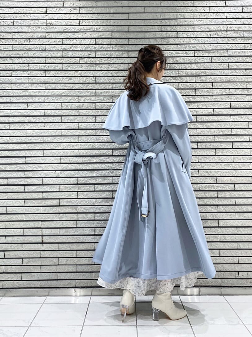 ブルー系のトレンチコート、ホワイト系のワンピース、ホワイト系のその他シューズを着用したレディースの冬コーディネートの2枚目の写真