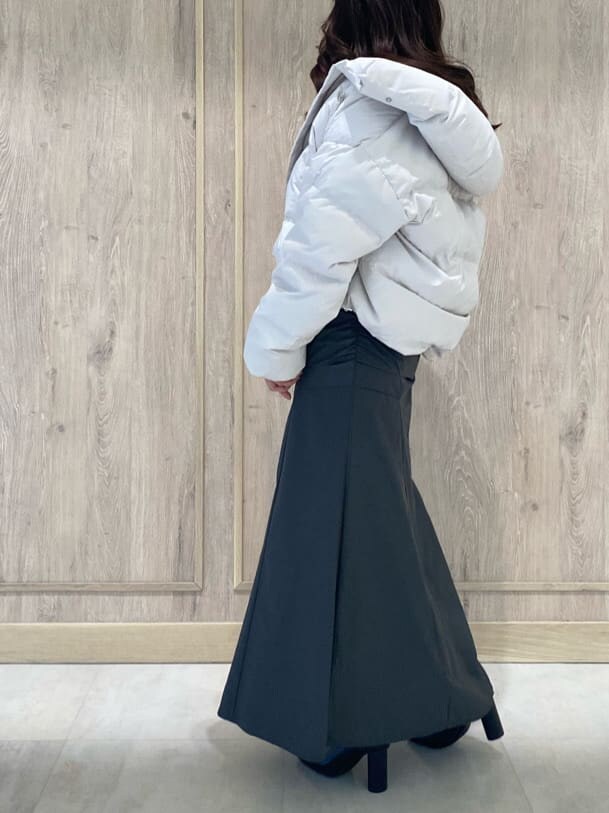 ホワイト系のダウンジャケット/コート、ブラック系のブーツ、パープル系のニット/セーターを着用したレディースの秋コーディネートの3枚目の写真