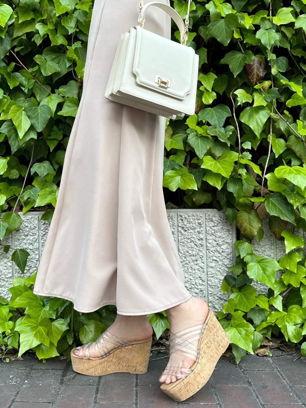 その他のサンダル、ホワイト系のハンドバッグ、ベージュ系のワンピースを着用したレディースの春コーディネートの7枚目の写真