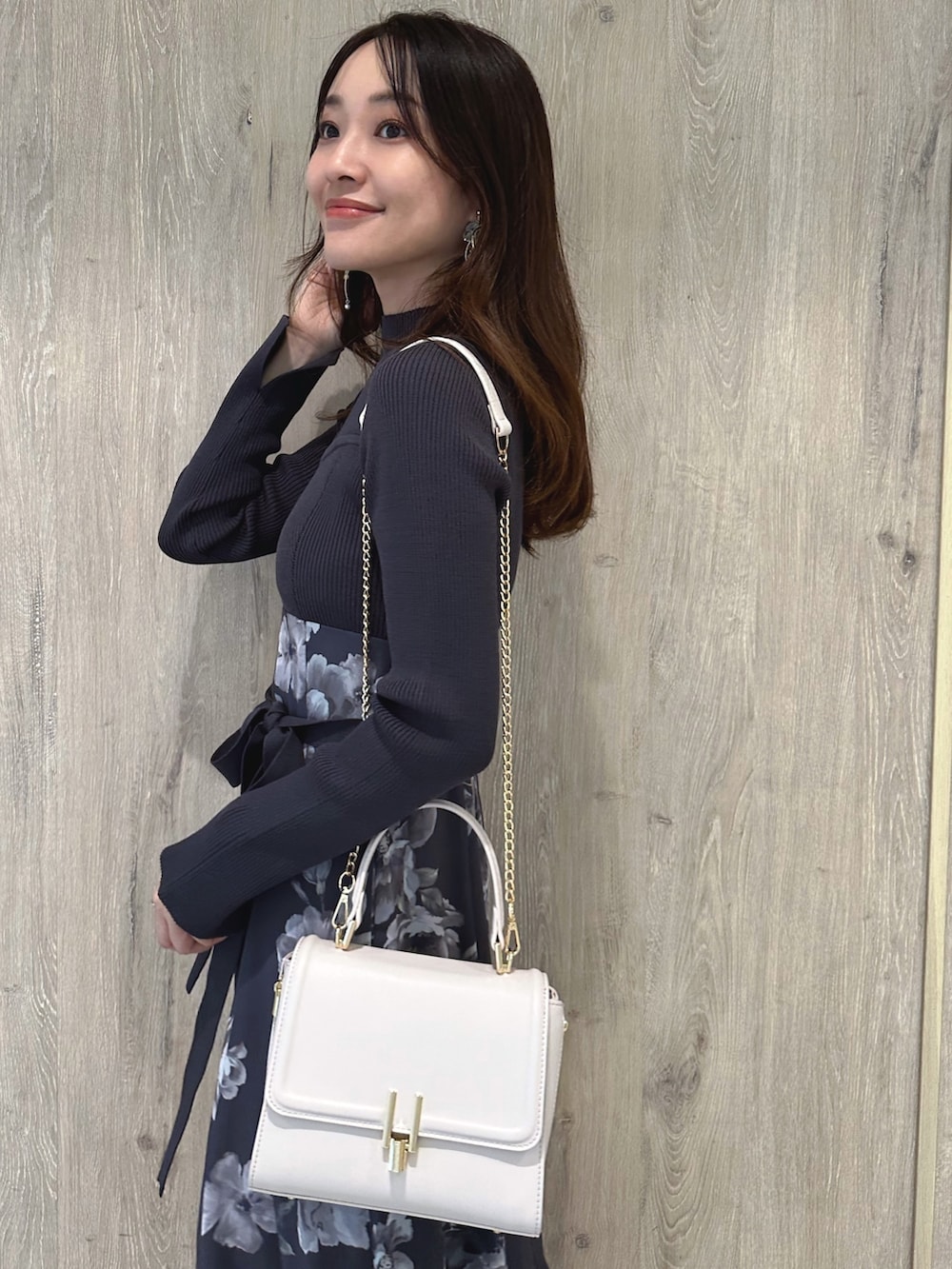 ピンク系のショルダーバッグ、ブラウン系のパンプス、パープル系のワンピースを着用したレディースの秋コーディネートの7枚目の写真