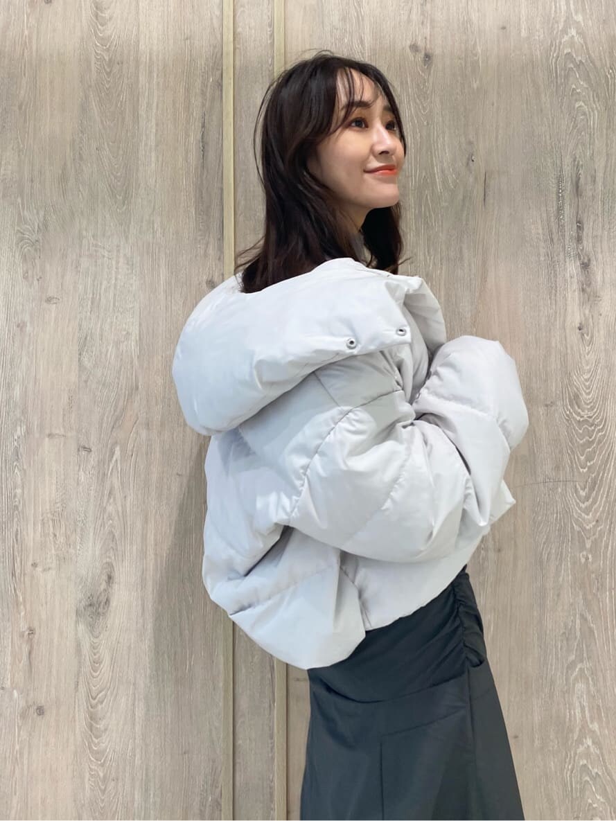 ホワイト系のダウンジャケット/コート、ブラック系のブーツ、パープル系のニット/セーターを着用したレディースの秋コーディネートの7枚目の写真