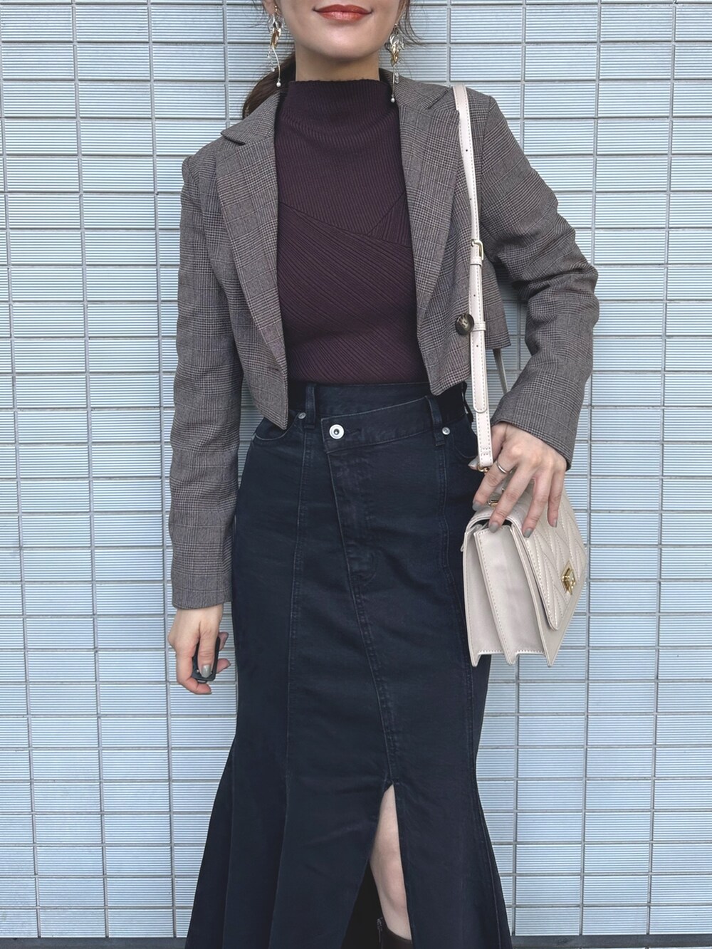 ベージュ系のショルダーバッグ、ブラック系のデニムスカート、ブラウン系のニット/セーターを着用したレディースの秋コーディネートの5枚目の写真