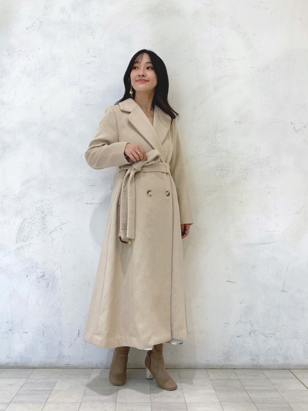 ホワイト系のワンピース、ベージュ系のブーツ、ベージュ系のチェスターコートを着用したレディースの冬コーディネートの8枚目の写真