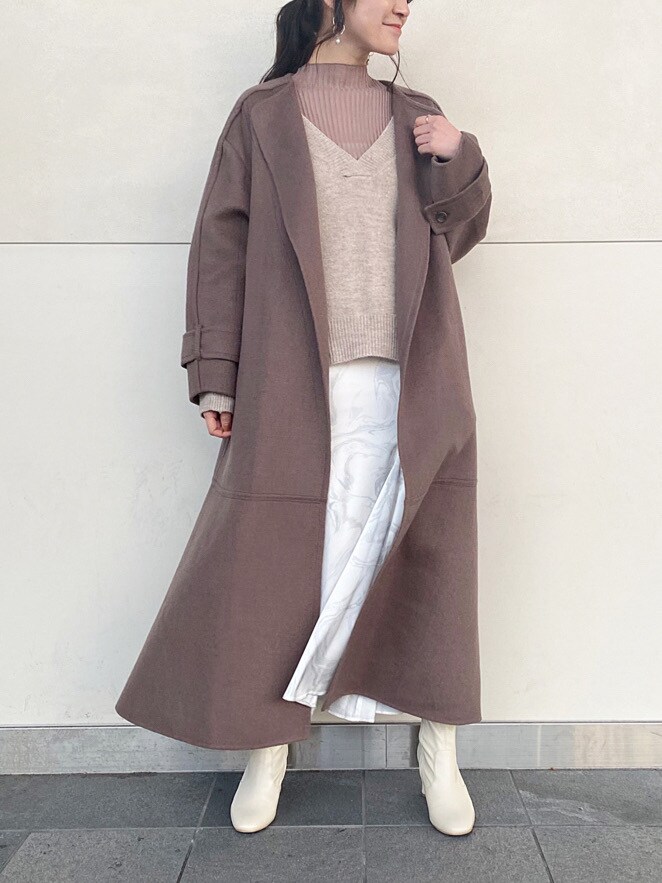 ホワイト系のブーツ、ホワイト系のスカート、ベージュ系のニット/セーターを着用したレディースの冬コーディネートの2枚目の写真