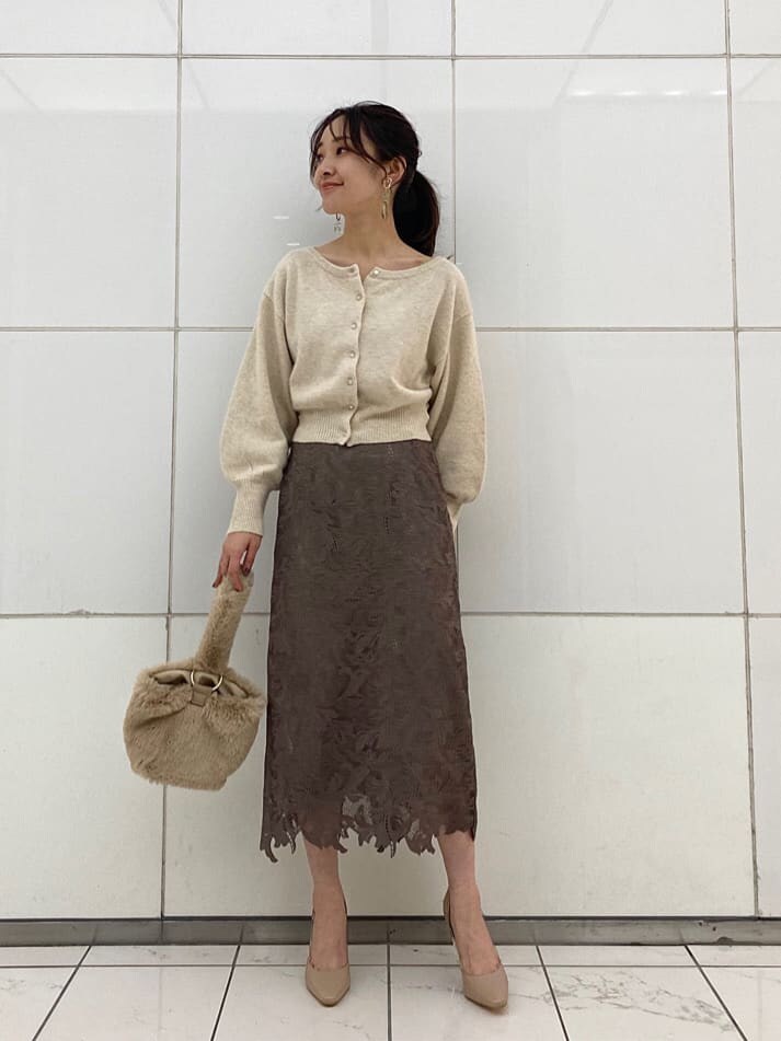 ベージュ系のパンプス、パープル系のチェスターコート、ホワイト系のニット/セーターを着用したレディースの冬コーディネートの6枚目の写真