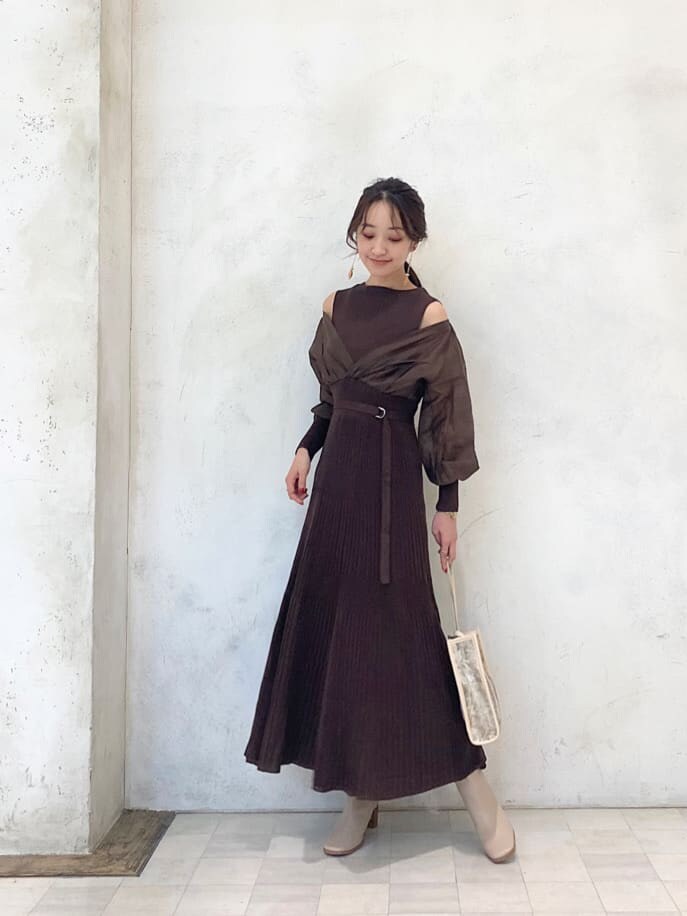 ベージュ系のハンドバッグ、ベージュ系のブーツ、ブラウン系のワンピースを着用したレディースの秋コーディネートの2枚目の写真