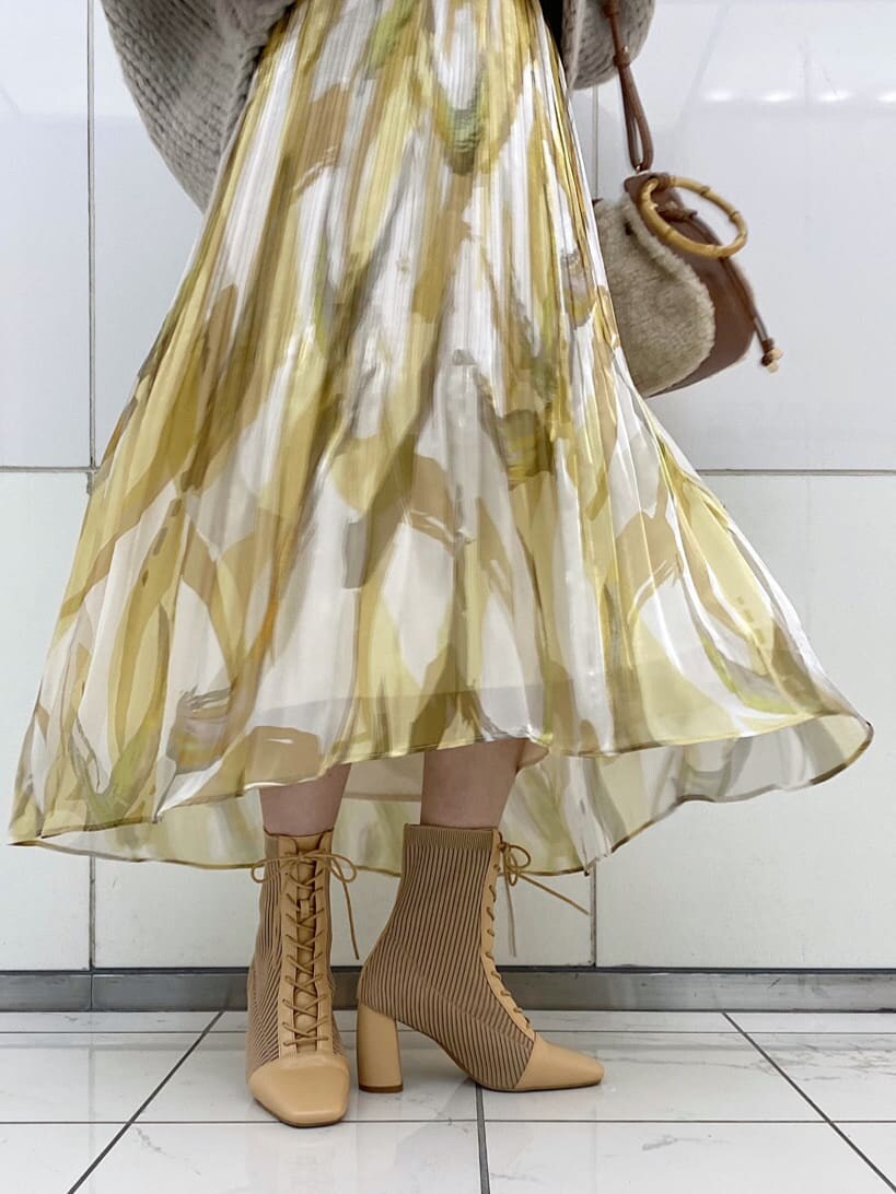 イエロー系のスカート、グレー系のニット/セーター、ベージュ系のブーツを着用したレディースの秋コーディネートの10枚目の写真