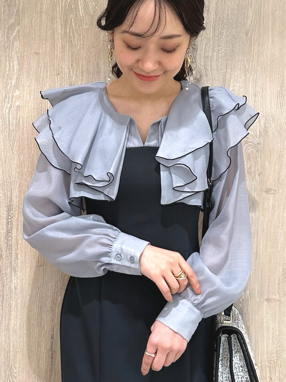 ブラック系のショルダーバッグ、グレー系のワンピース、ブラウン系のパンプスを着用したレディースの冬コーディネートの5枚目の写真