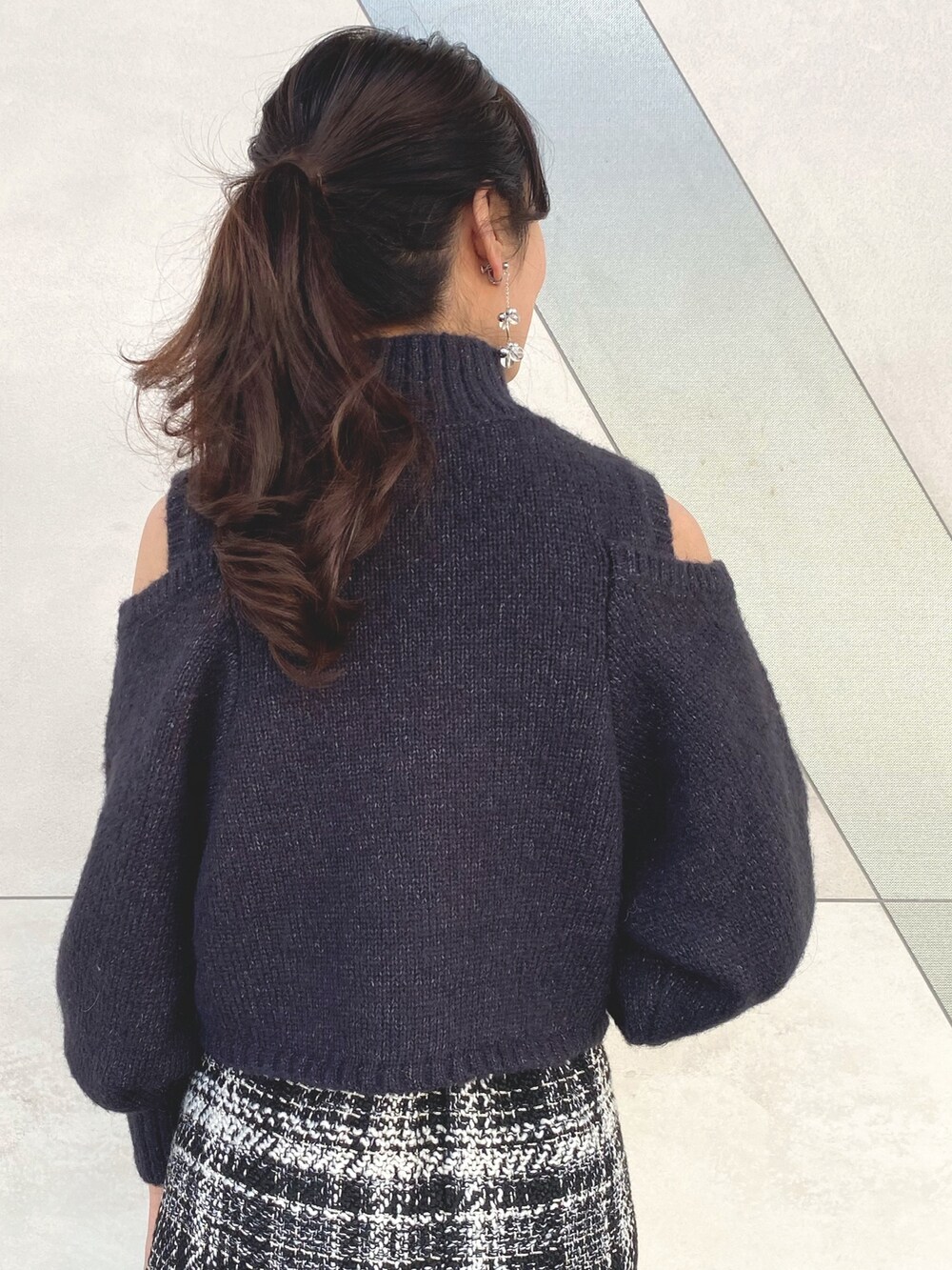 グレー系のニット/セーター、ブラック系のスカート、ブラック系のブーツを着用したレディースの秋コーディネートの6枚目の写真