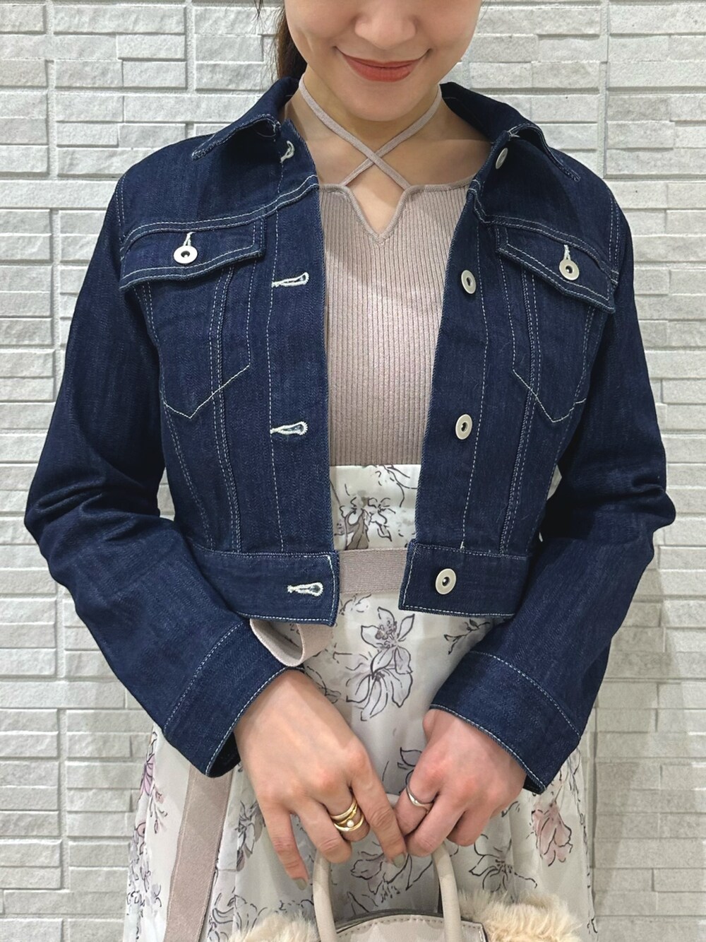 ブラウン系のブーツ、ホワイト系のハンドバッグ、ブルー系のデニムジャケットを着用したレディースの夏コーディネートの6枚目の写真