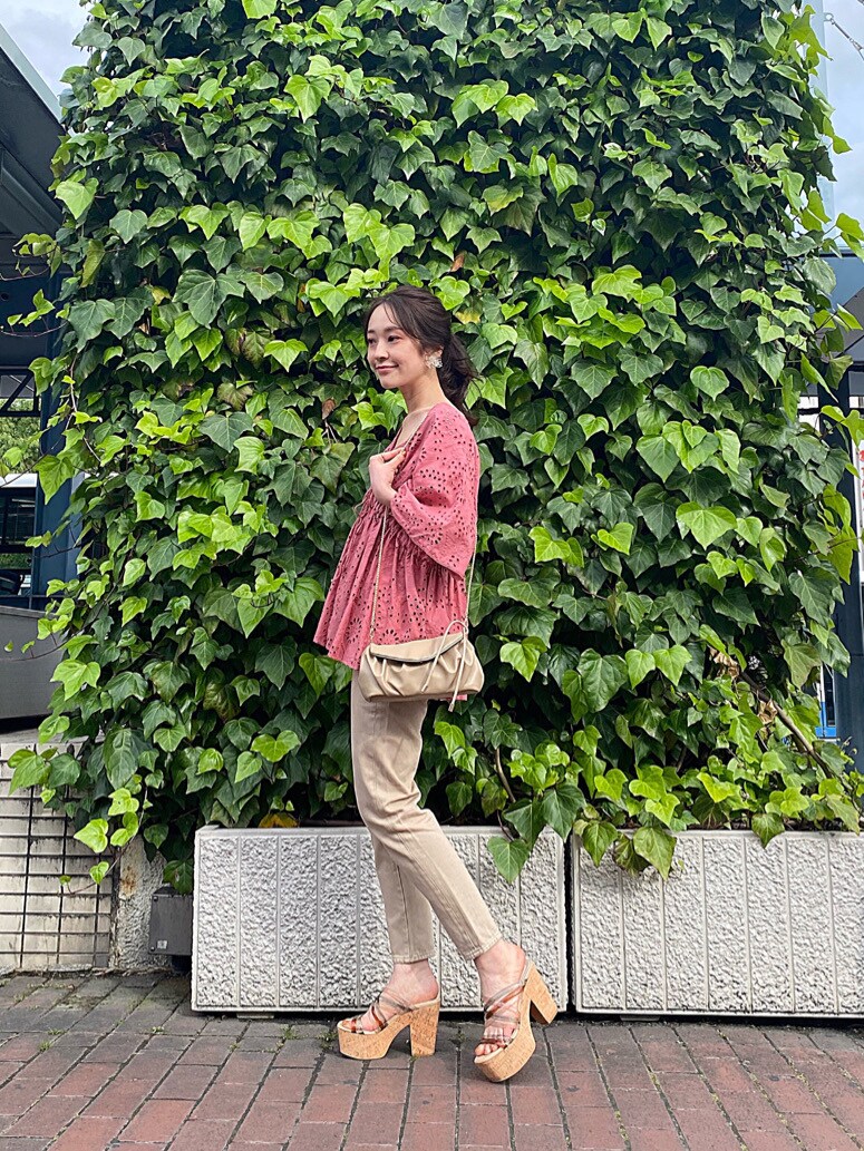 ベージュ系のその他パンツ、グリーン系のサンダル、ベージュ系のクラッチバッグを着用したレディースの春コーディネートの4枚目の写真