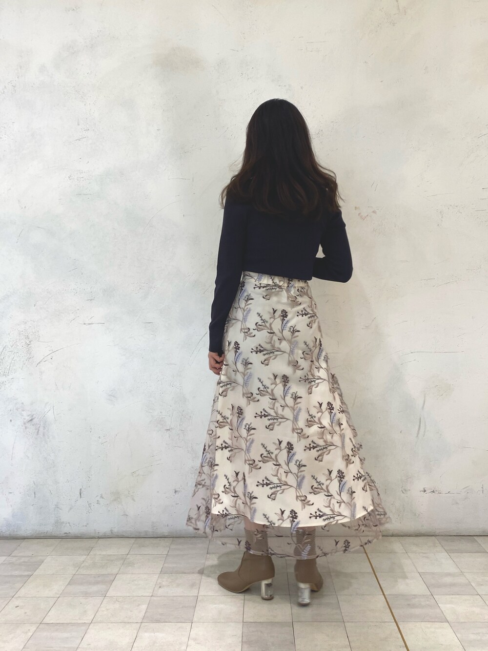 ブラウン系のニット/セーター、ピンク系のスカート、ベージュ系のブーツを着用したレディースの秋コーディネートの4枚目の写真