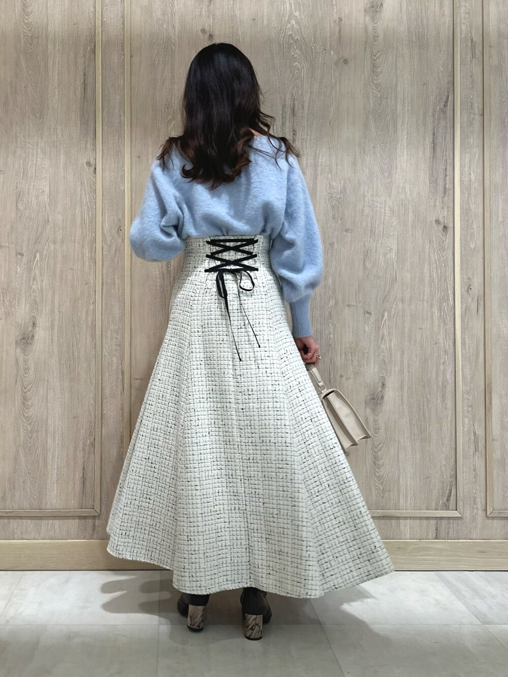 ホワイト系のスカート、ブルー系のカーディガン/ボレロ、ブラウン系のブーツを着用したレディースの秋コーディネートの4枚目の写真