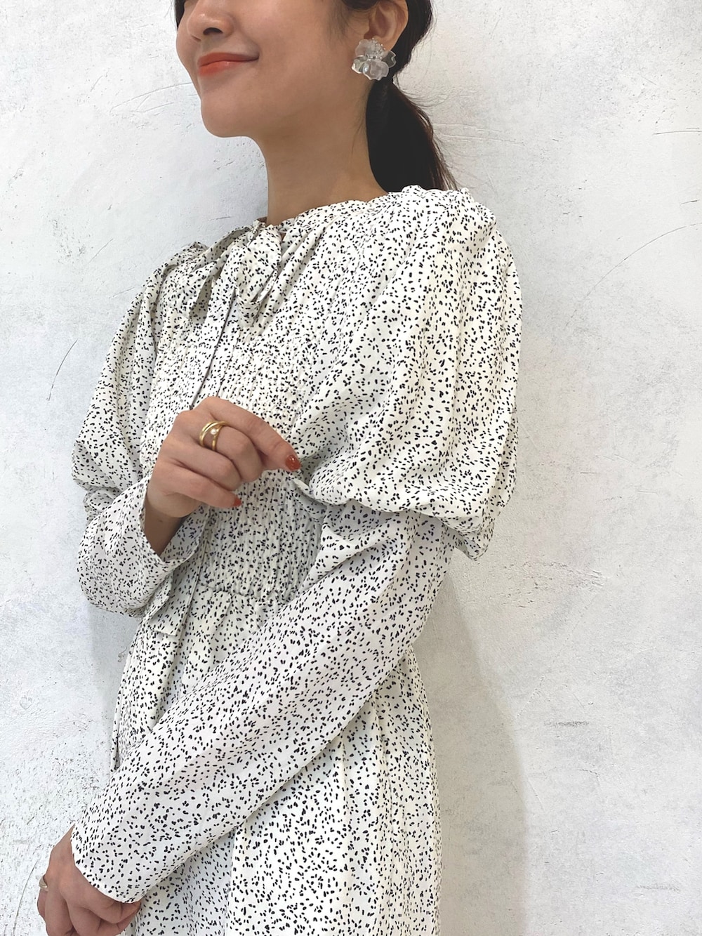 ホワイト系のワンピース、ベージュ系のブーツ、シルバー系のイヤリングを着用したレディースの秋コーディネートの6枚目の写真