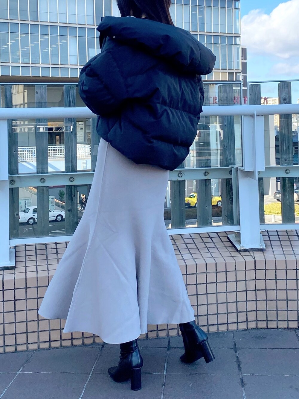 ブラック系のブーツ、ベージュ系のワンピース、ブラック系のダウンジャケット/コートを着用したレディースの冬コーディネートの4枚目の写真