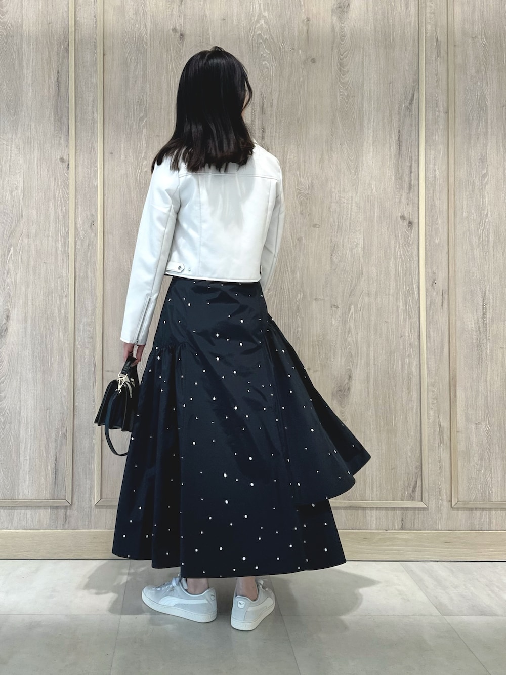 ピンク系のニット/セーター、ブラック系のハンドバッグ、その他のスカートを着用したレディースの春コーディネートの4枚目の写真