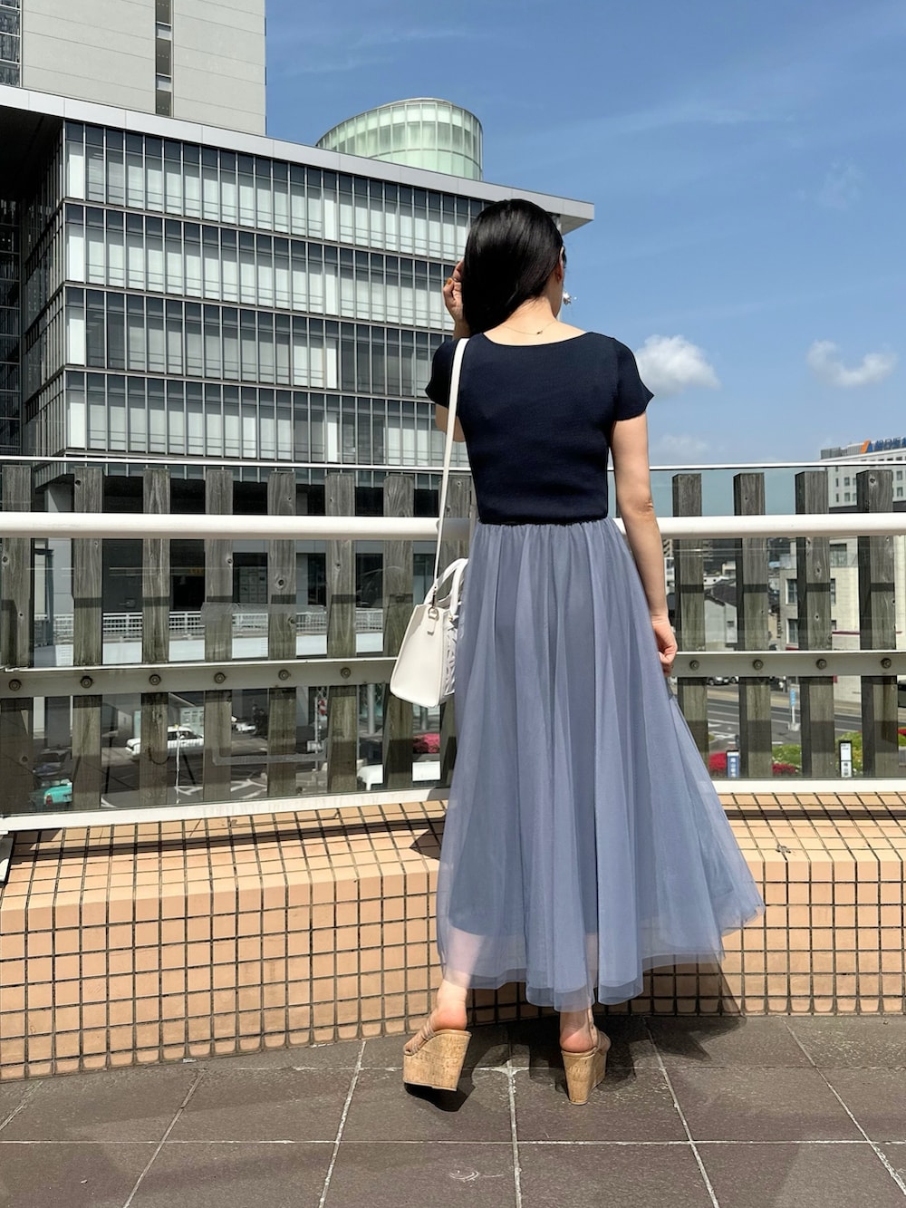 その他のサンダル、ホワイト系のショルダーバッグ、ブルー系のワンピースを着用したレディースの春コーディネートの4枚目の写真