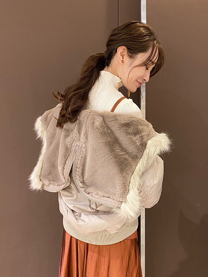ベージュ系のブルゾン、ホワイト系のニット/セーター、ゴールド系のイヤリングを着用したレディースの秋コーディネートの3枚目の写真