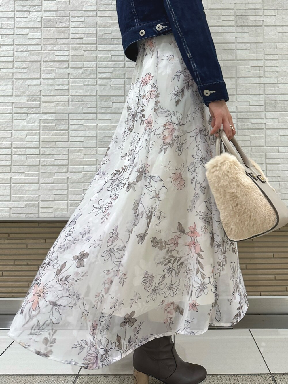 ブラウン系のブーツ、ホワイト系のハンドバッグ、ブルー系のデニムジャケットを着用したレディースの夏コーディネートの9枚目の写真