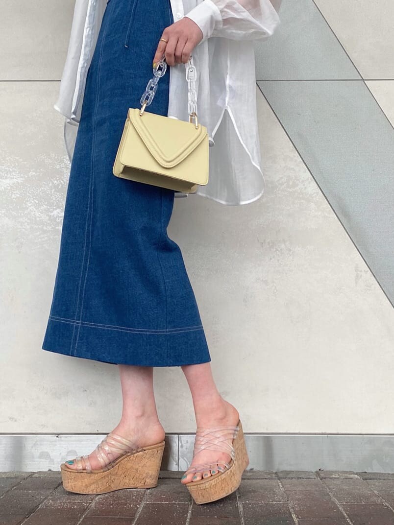 イエロー系のショルダーバッグ、ブルー系のジャンパースカート、ベージュ系のキャミソールを着用したレディースの春コーディネートの8枚目の写真