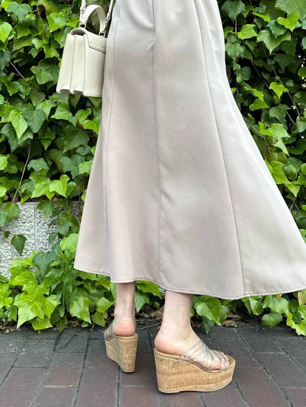 その他のサンダル、ホワイト系のハンドバッグ、ベージュ系のワンピースを着用したレディースの春コーディネートの8枚目の写真