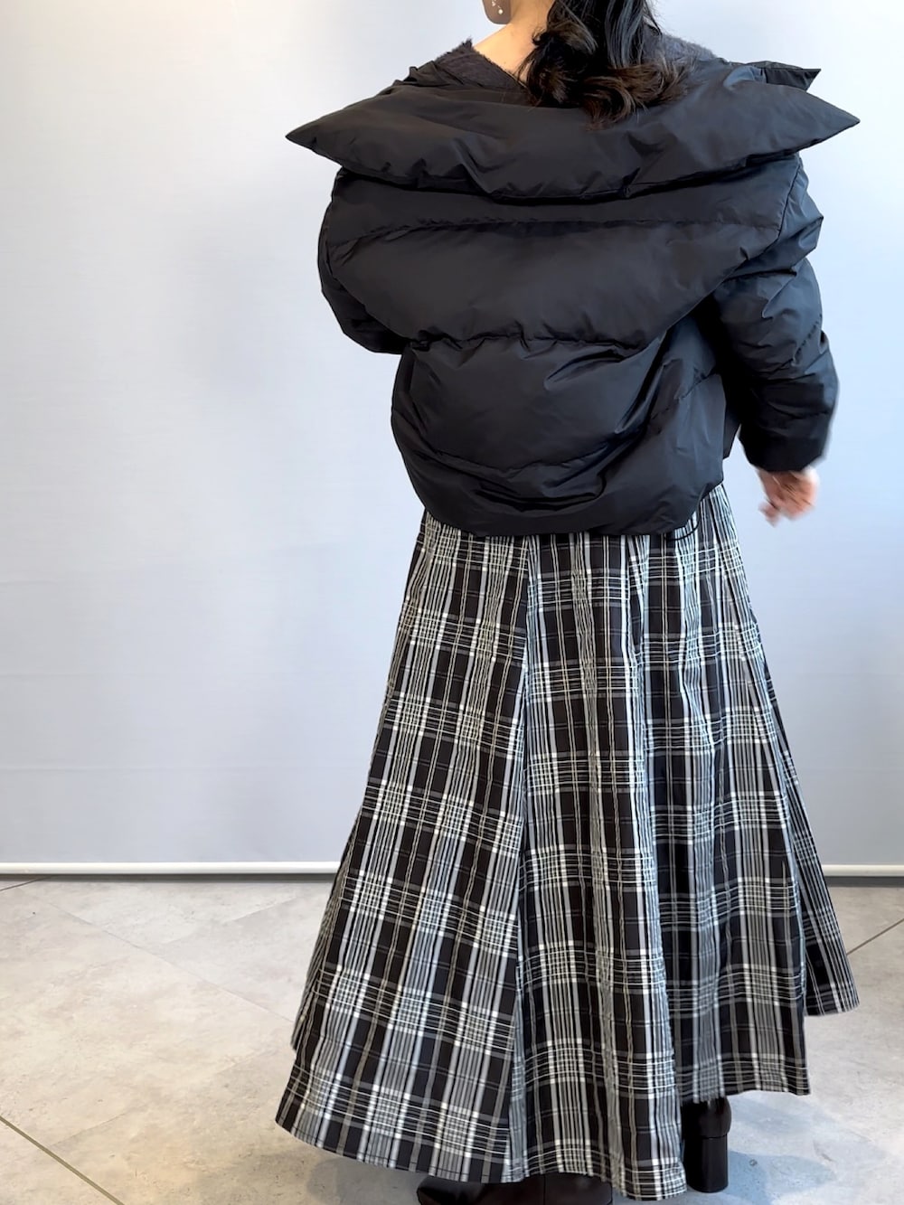 ブラック系のスカート、ブラウン系のブーツ、グレー系のニット/セーターを着用したレディースの冬コーディネートの3枚目の写真