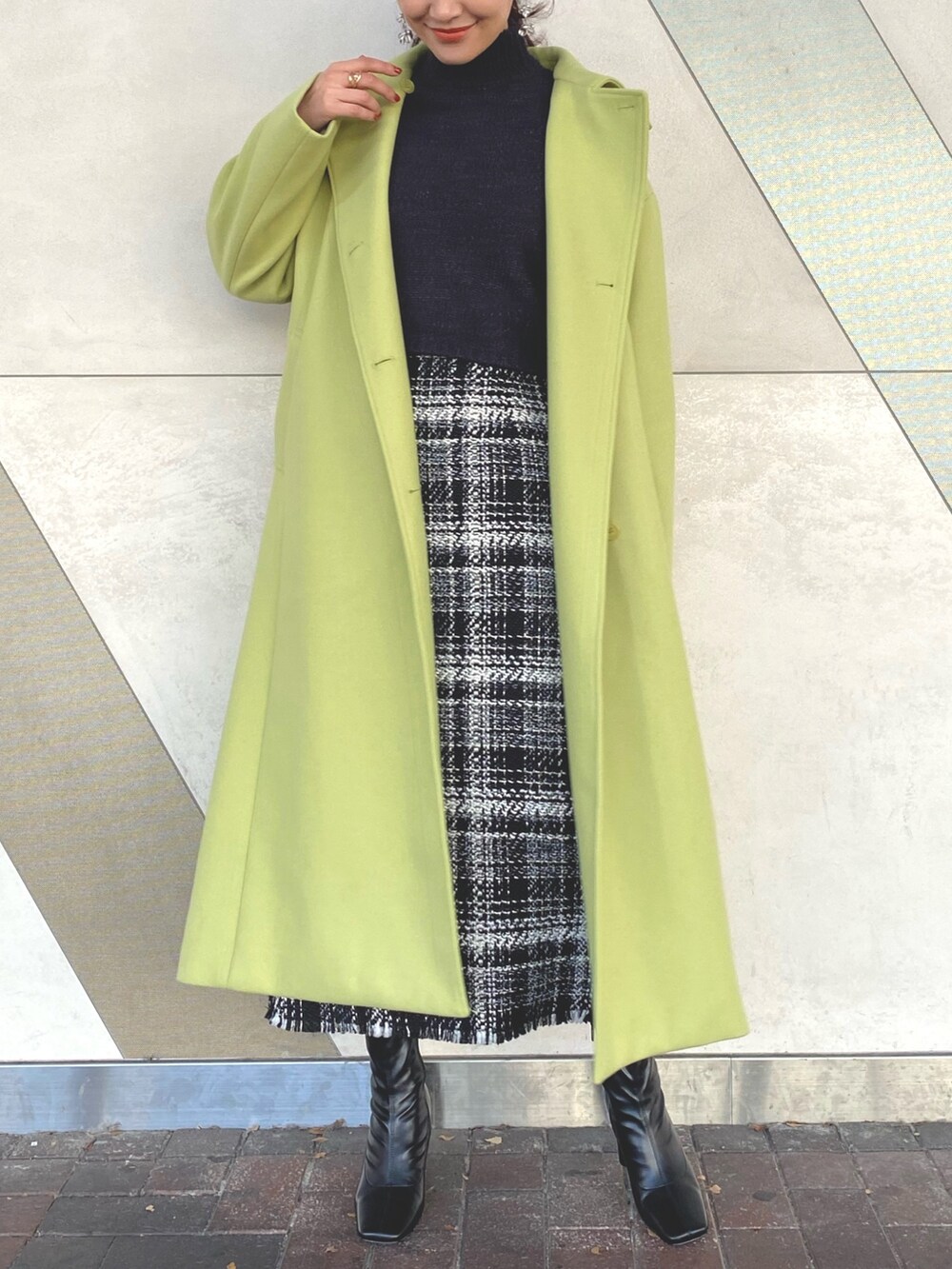 ブラック系のブーツ、グリーン系のステンカラーコート、グリーン系のステンカラーコートを着用したレディースの秋コーディネートの2枚目の写真