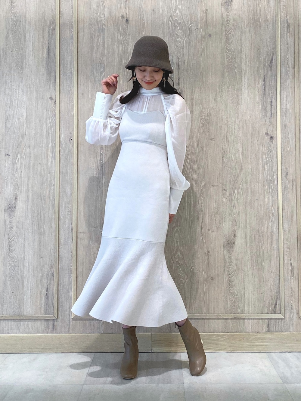 ベージュ系のブーツ、ホワイト系のワンピース、ホワイト系のチューブトップを着用したレディースの冬コーディネートの2枚目の写真