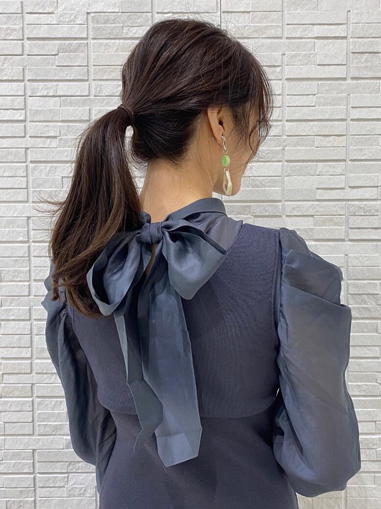 グレー系のテーラードジャケット、ブルー系のワンピース、ホワイト系のその他シューズを着用したレディースの冬コーディネートの9枚目の写真