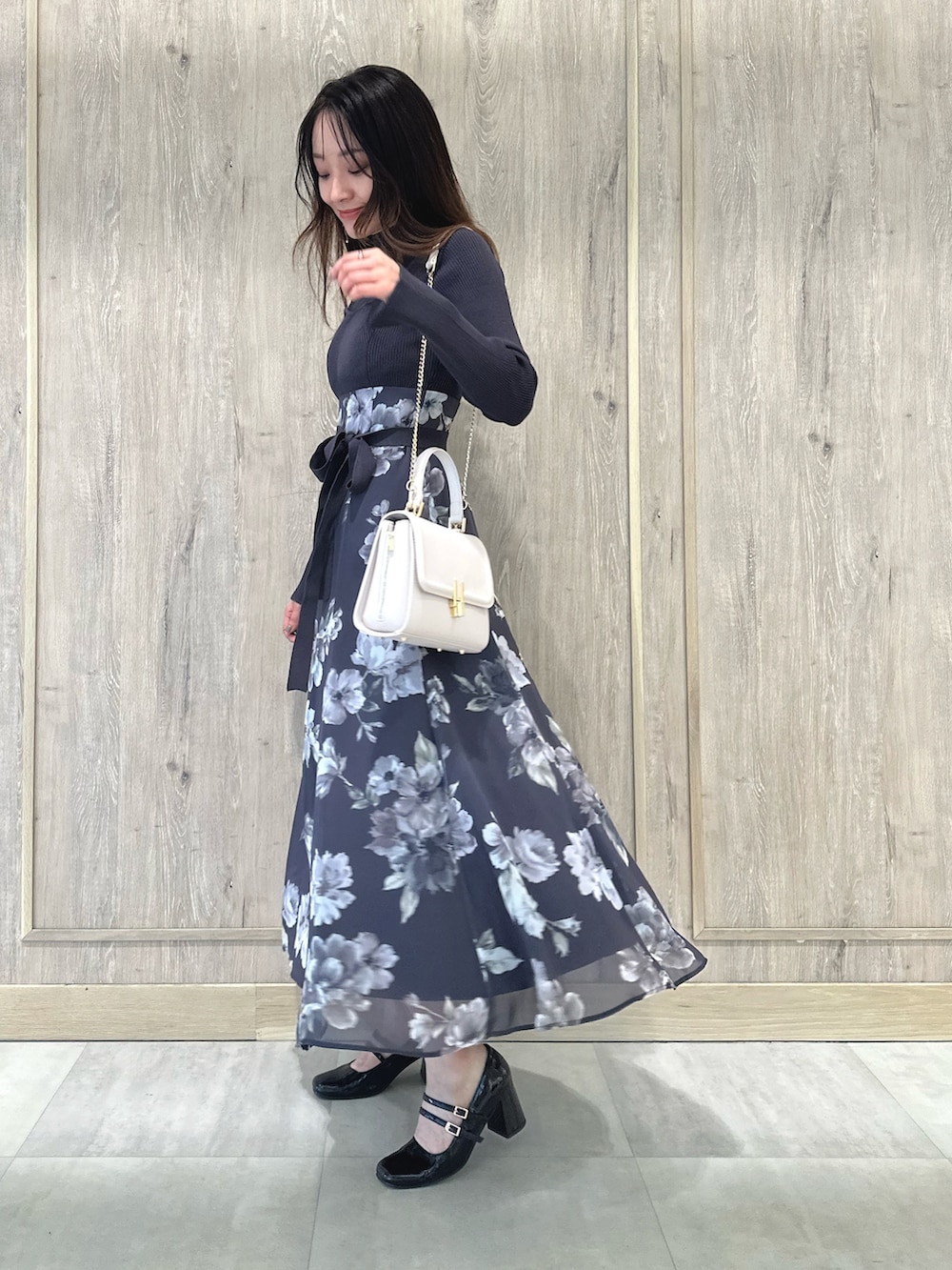 ピンク系のショルダーバッグ、ブラウン系のパンプス、パープル系のワンピースを着用したレディースの秋コーディネートの3枚目の写真