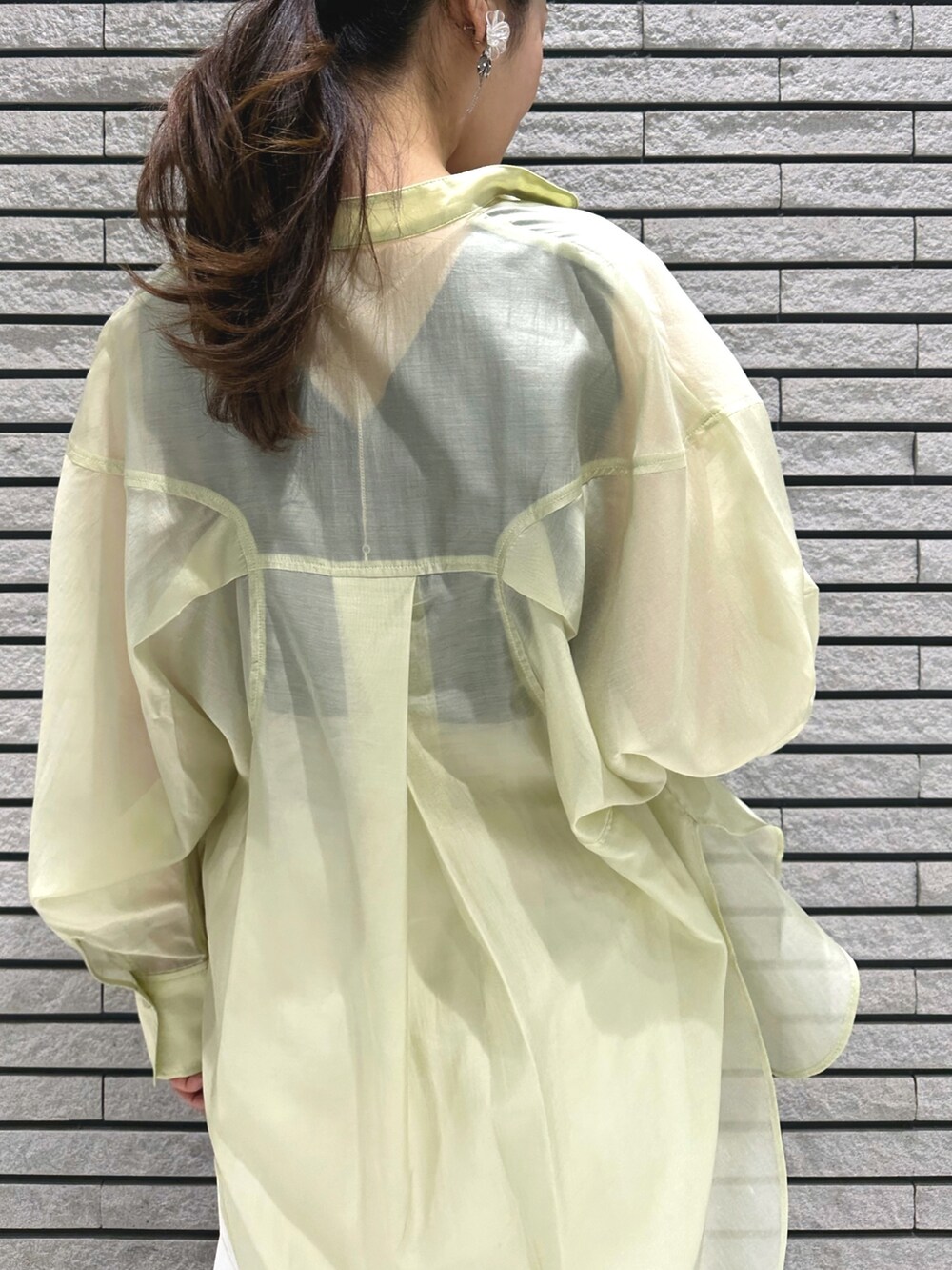 シルバー系のサンダル、ホワイト系のスカート、グレー系のニット/セーターを着用したレディースの春コーディネートの7枚目の写真