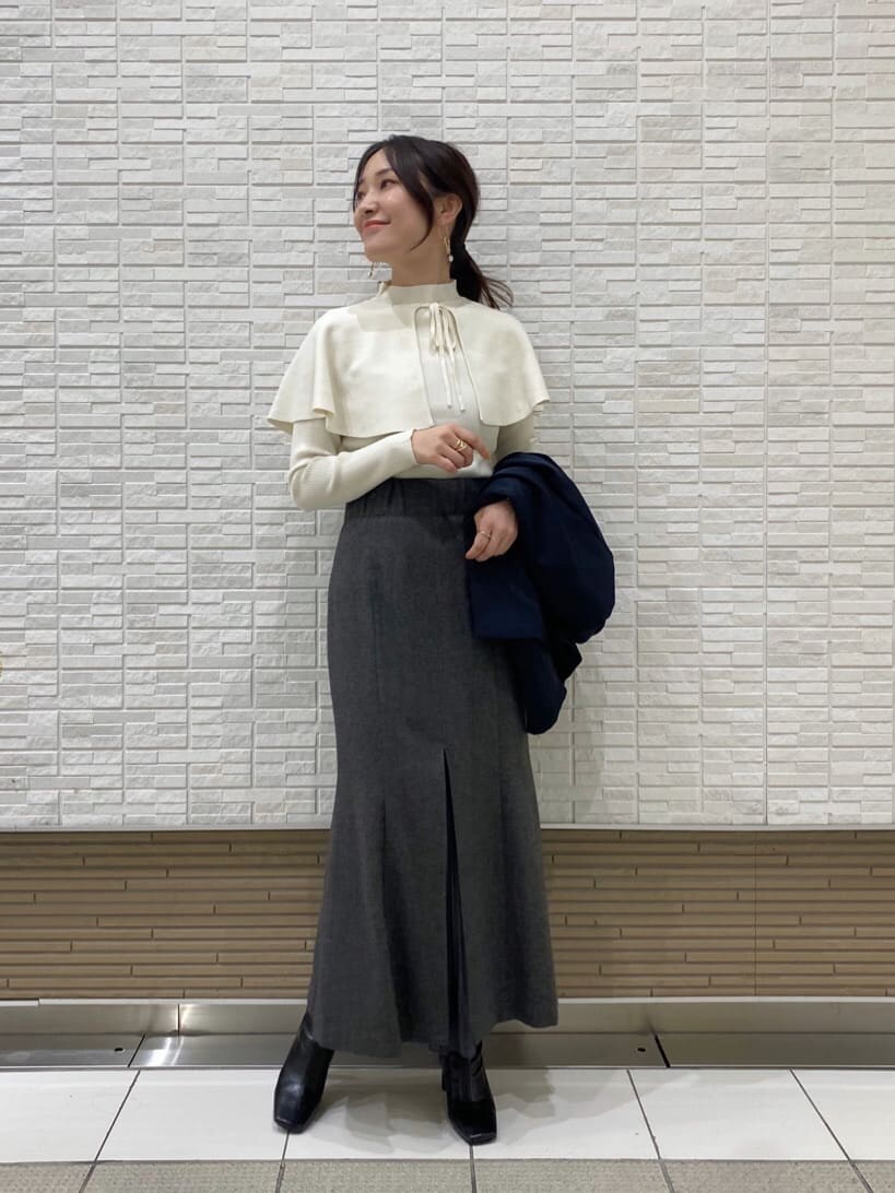 ブラック系のブーツ、ブルー系のテーラードジャケット、グレー系のスカートを着用したレディースの秋コーディネートの7枚目の写真