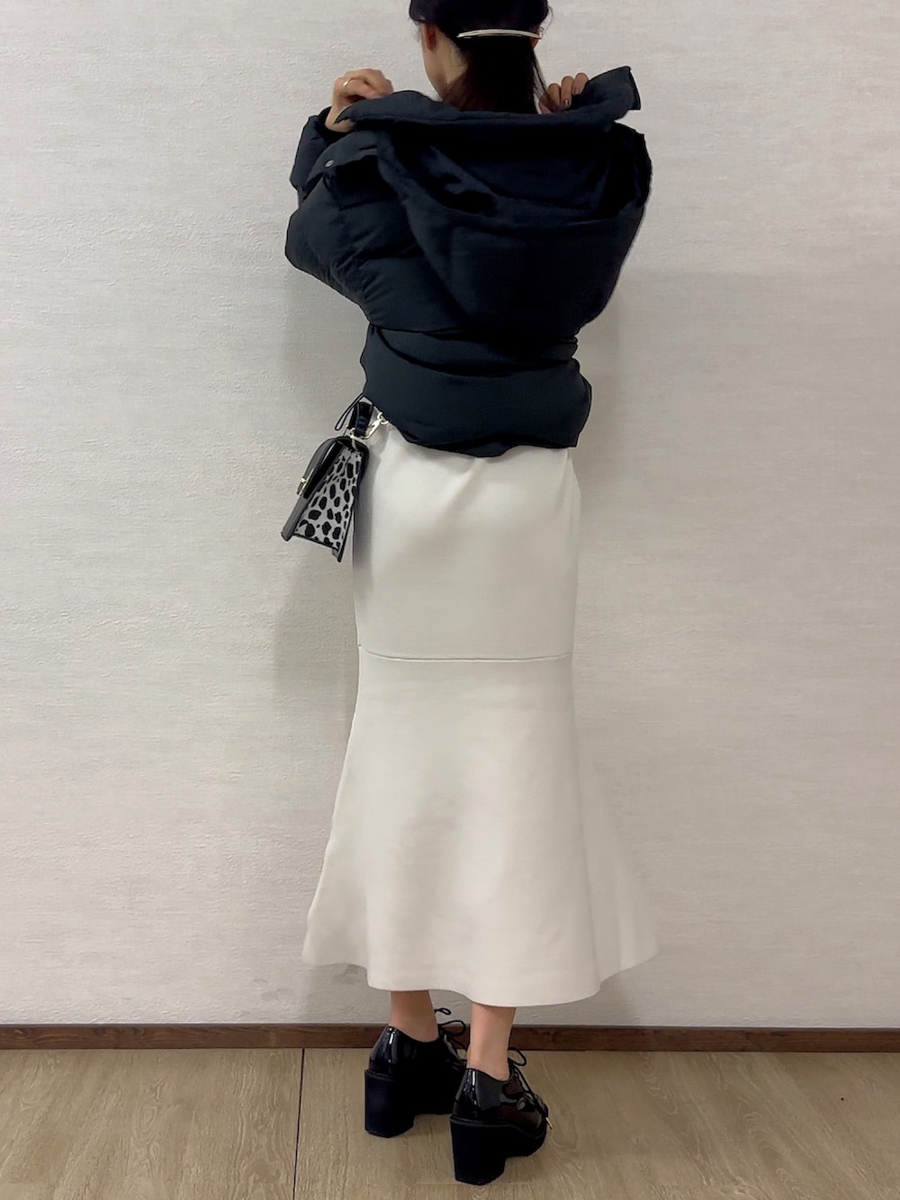 ブラック系のローファー、ホワイト系のワンピース、ブラック系のハンドバッグを着用したレディースの秋コーディネートの3枚目の写真