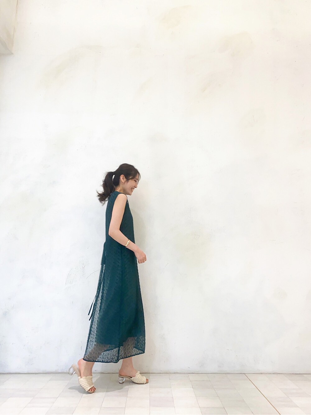 ホワイト系のサンダル、グリーン系のワンピース、ホワイト系のハンドバッグを着用したレディースの春コーディネートの2枚目の写真