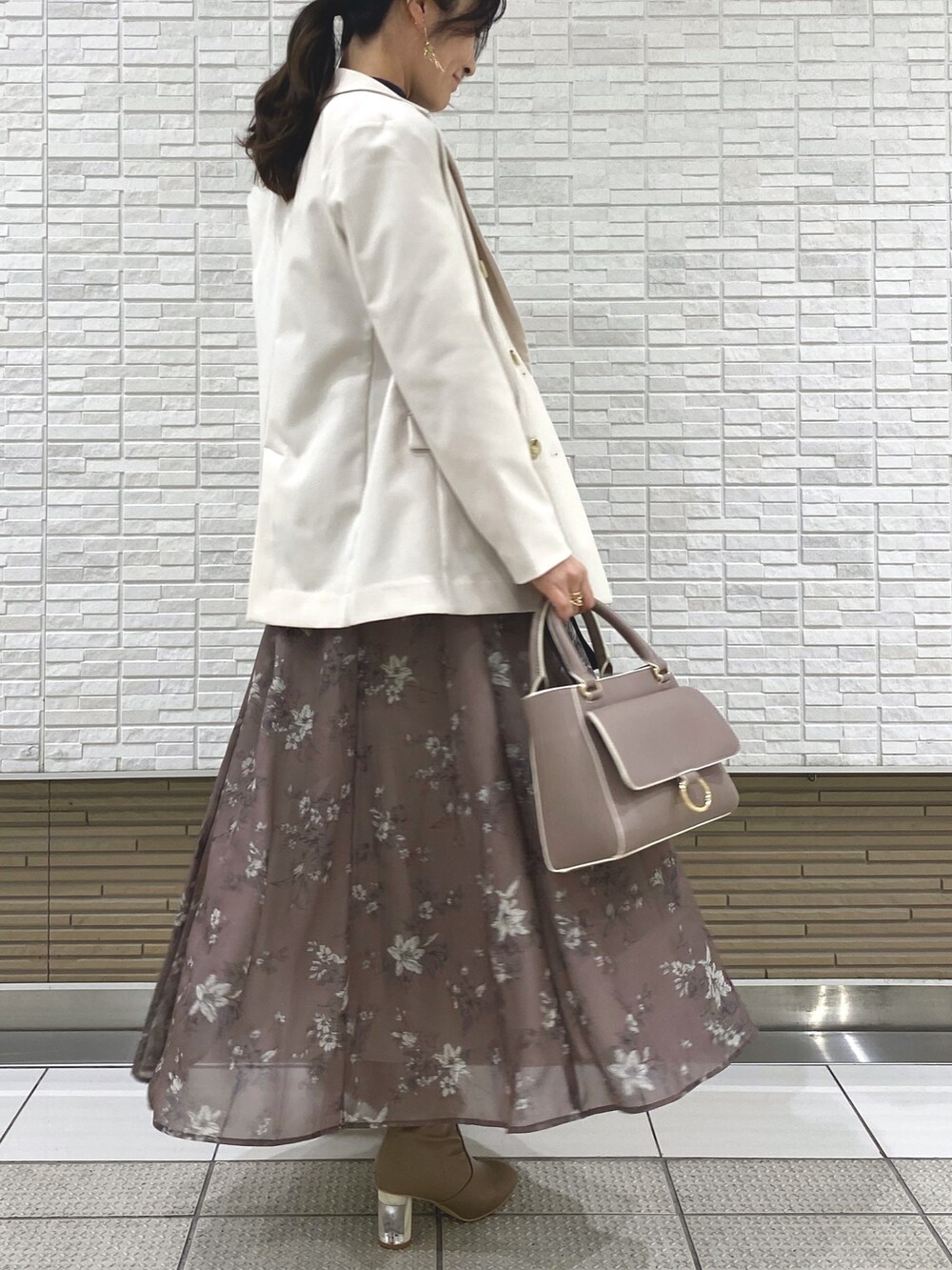 ベージュ系のブーツ、ホワイト系のテーラードジャケット、ベージュ系のハンドバッグを着用したレディースの冬コーディネートの3枚目の写真