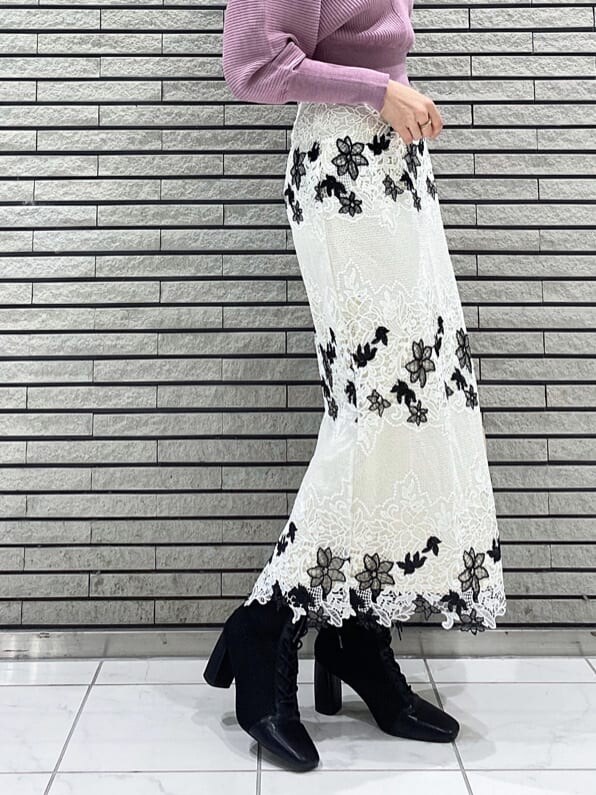 ホワイト系のスカート、ブラック系のブーツ、ピンク系のニット/セーターを着用したレディースの冬コーディネートの5枚目の写真