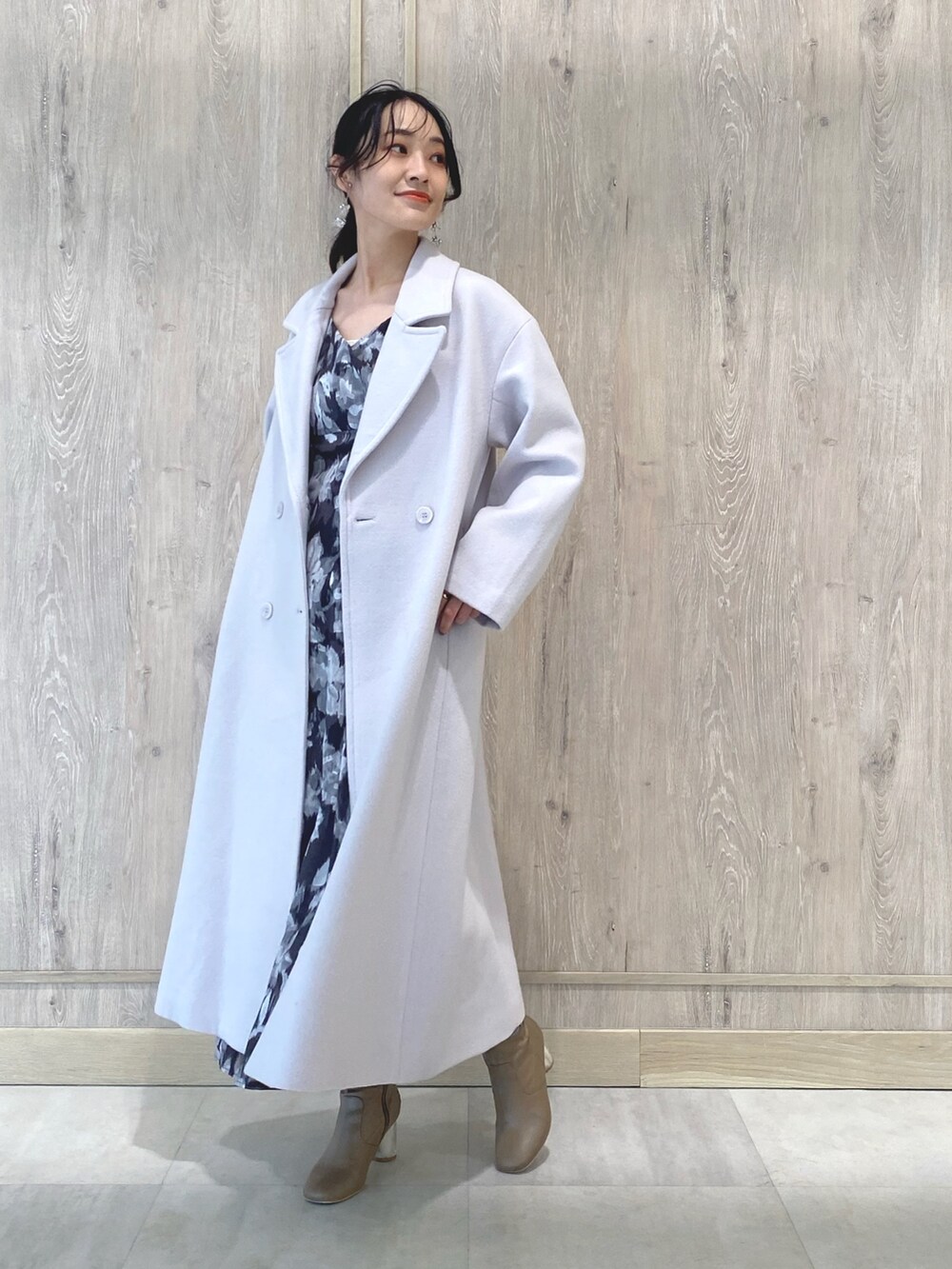 ベージュ系のブーツ、ピンク系のチェスターコート、ブラック系のワンピースを着用したレディースの冬コーディネートの3枚目の写真