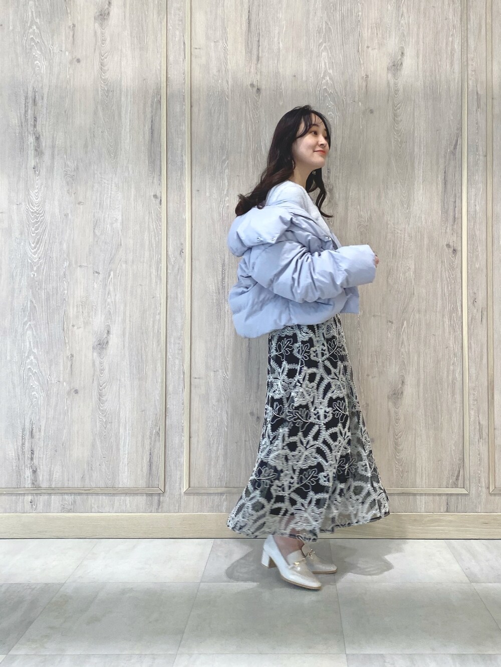 ホワイト系のローファー、グレー系のカーディガン/ボレロ、ブラック系のスカートを着用したレディースの冬コーディネートの2枚目の写真