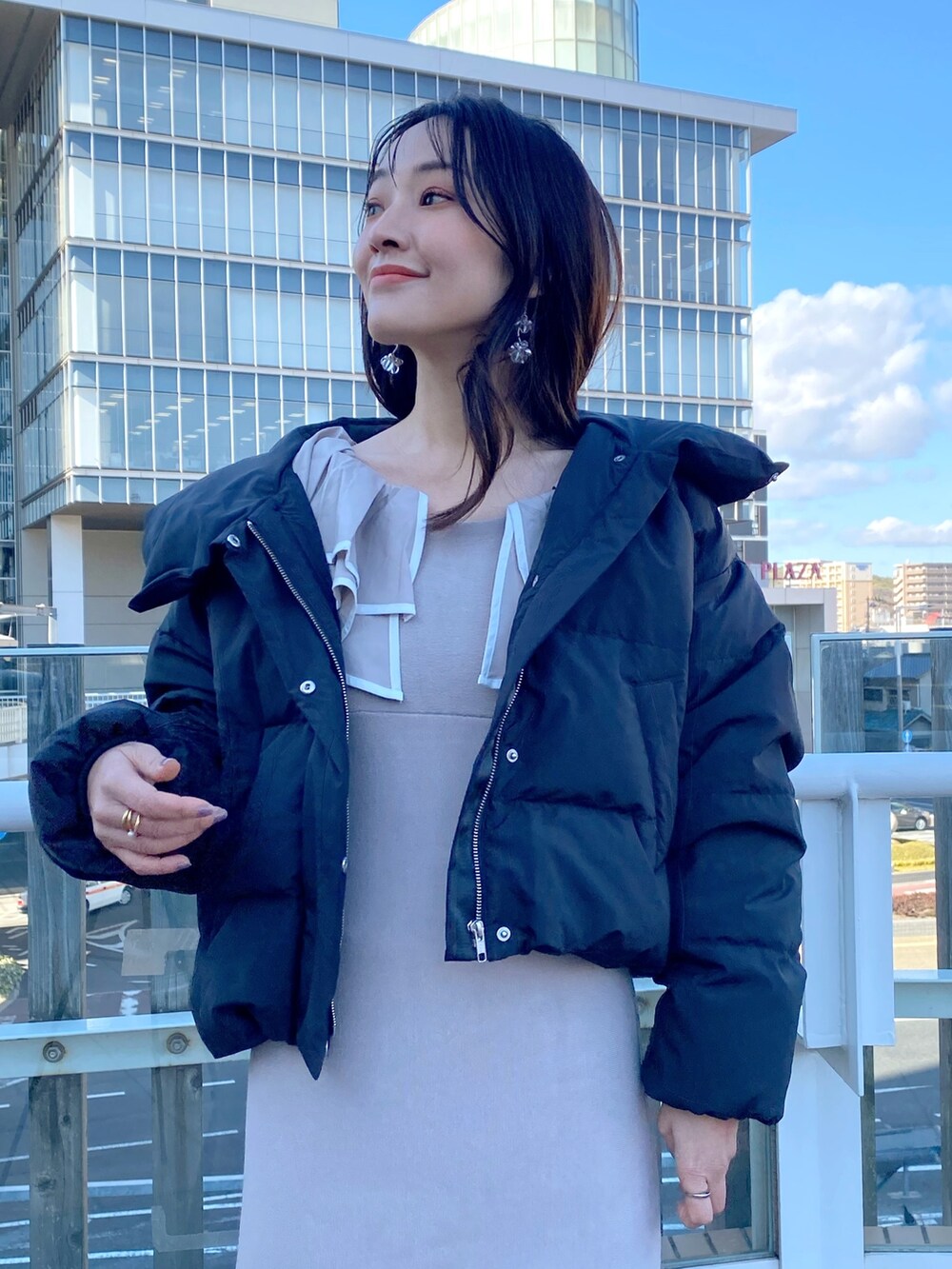 ブラック系のブーツ、ベージュ系のワンピース、ブラック系のダウンジャケット/コートを着用したレディースの冬コーディネートの5枚目の写真