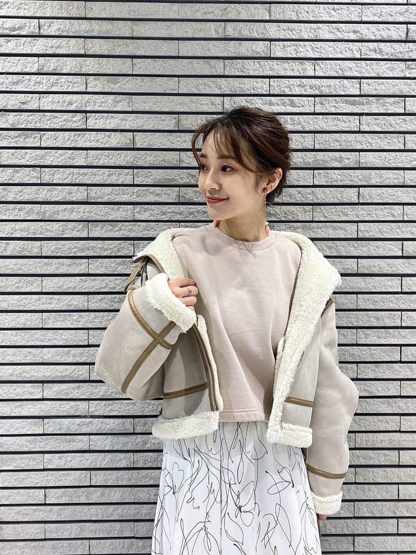 ベージュ系のハンドバッグ、ベージュ系のTシャツ/カットソー、ブルー系のワンピースを着用したレディースの秋コーディネートの4枚目の写真