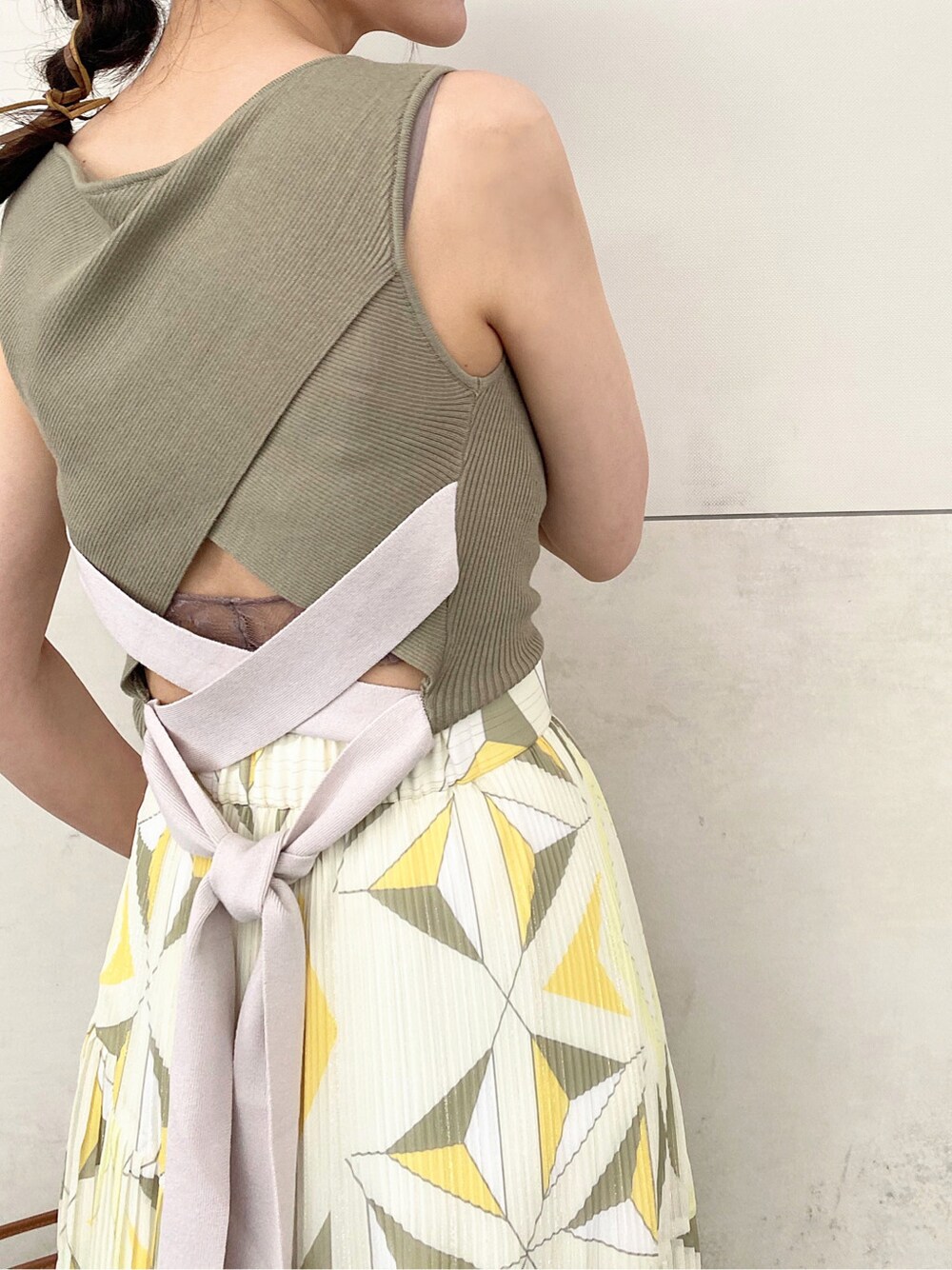 ブラウン系のトートバッグ、ベージュ系のサンダル、イエロー系のスカートを着用したレディースの夏コーディネートの6枚目の写真