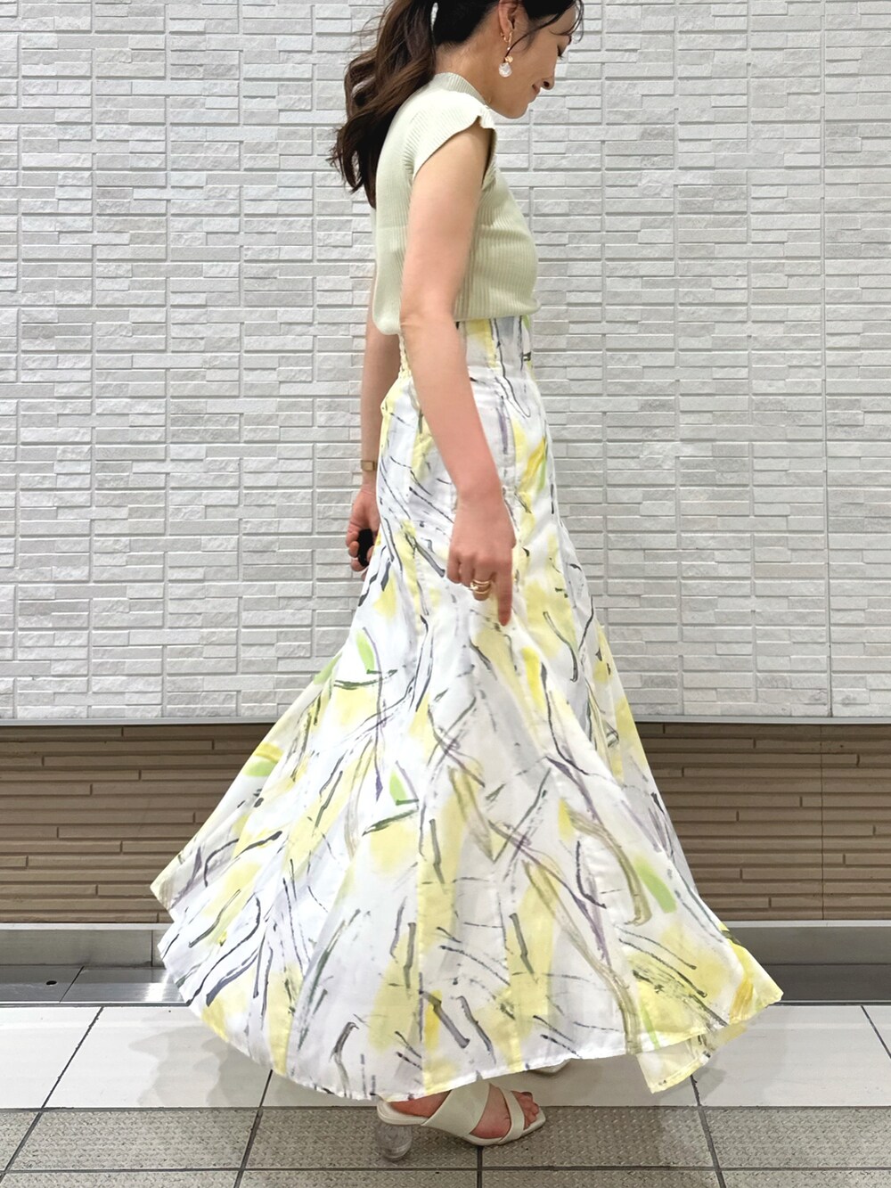 ホワイト系のキャミソール、ホワイト系のサンダル、イエロー系のスカートを着用したレディースの夏コーディネートの4枚目の写真