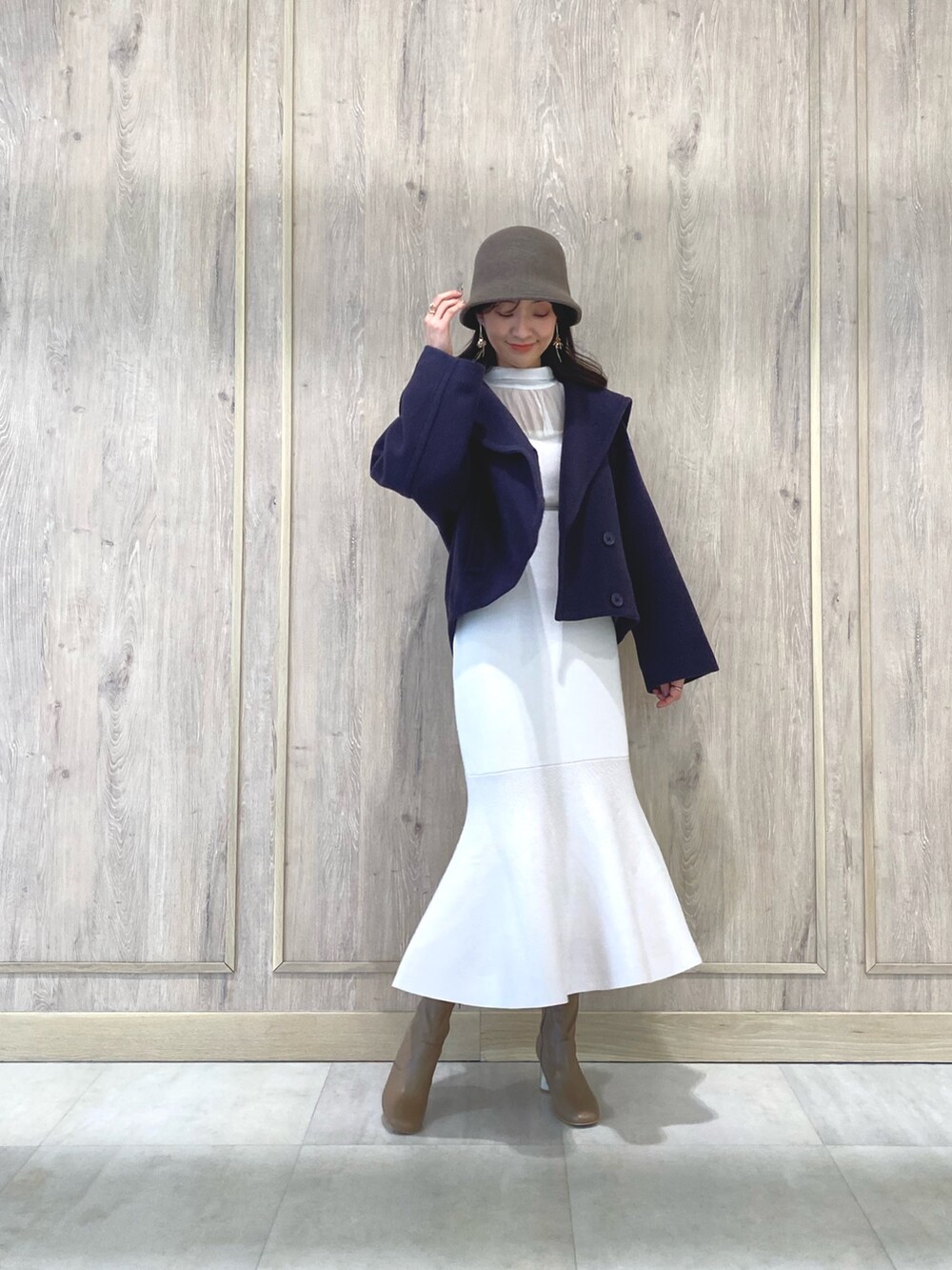 ベージュ系のブーツ、パープル系のその他アウター、ホワイト系のキャミソールを着用したレディースの冬コーディネートの2枚目の写真