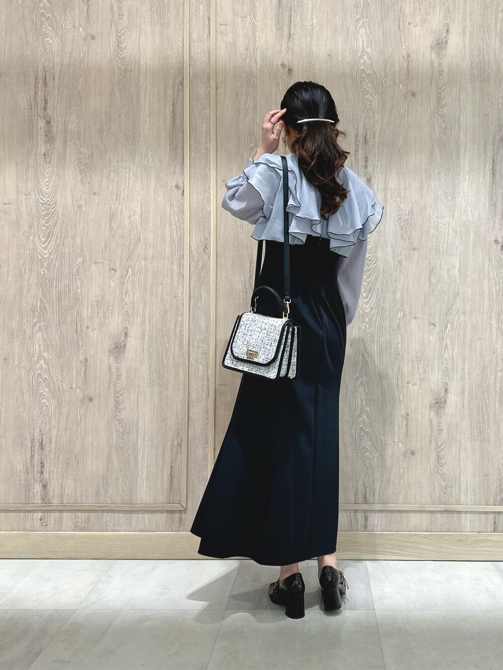 ブラック系のショルダーバッグ、グレー系のワンピース、ブラウン系のパンプスを着用したレディースの冬コーディネートの4枚目の写真