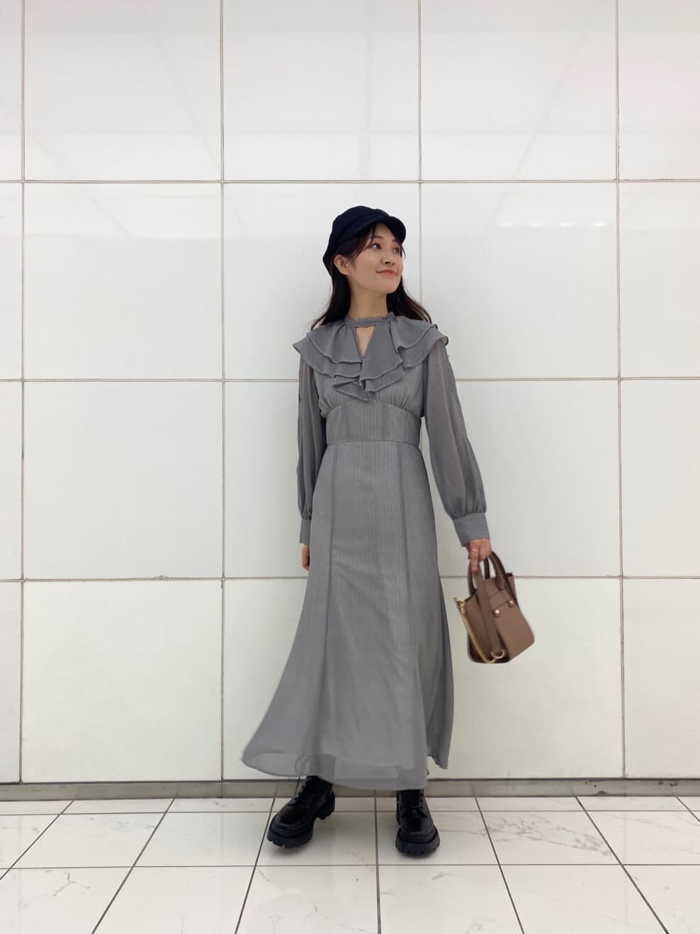 ブラック系のブーツ、ブラウン系のハンドバッグ、ブラック系のワンピースを着用したレディースの夏コーディネートの3枚目の写真