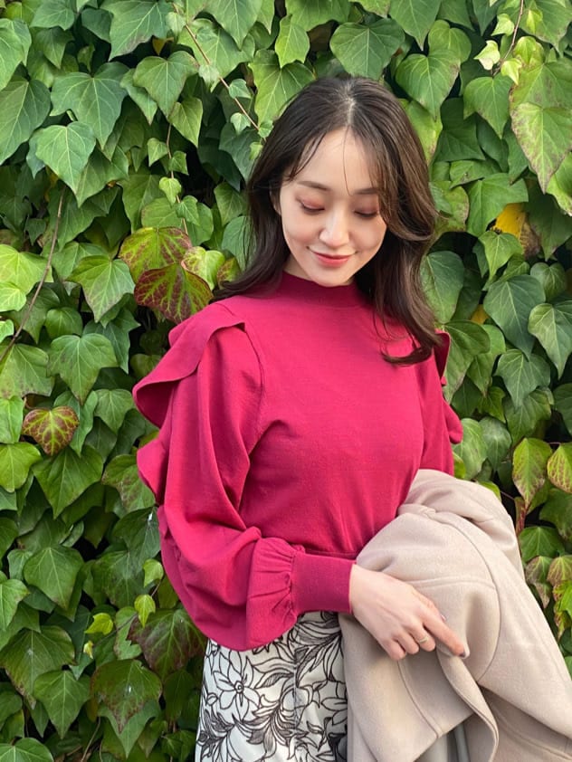 ブラウン系のその他シューズ、ベージュ系のステンカラーコート、レッド系のニット/セーターを着用したレディースの冬コーディネートの2枚目の写真