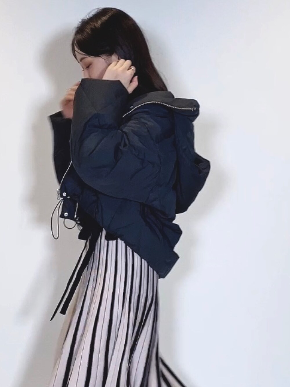 ブラック系のブーツ、ブラック系のワンピース、ブラック系のダウンジャケット/コートを着用したレディースの冬コーディネートの4枚目の写真