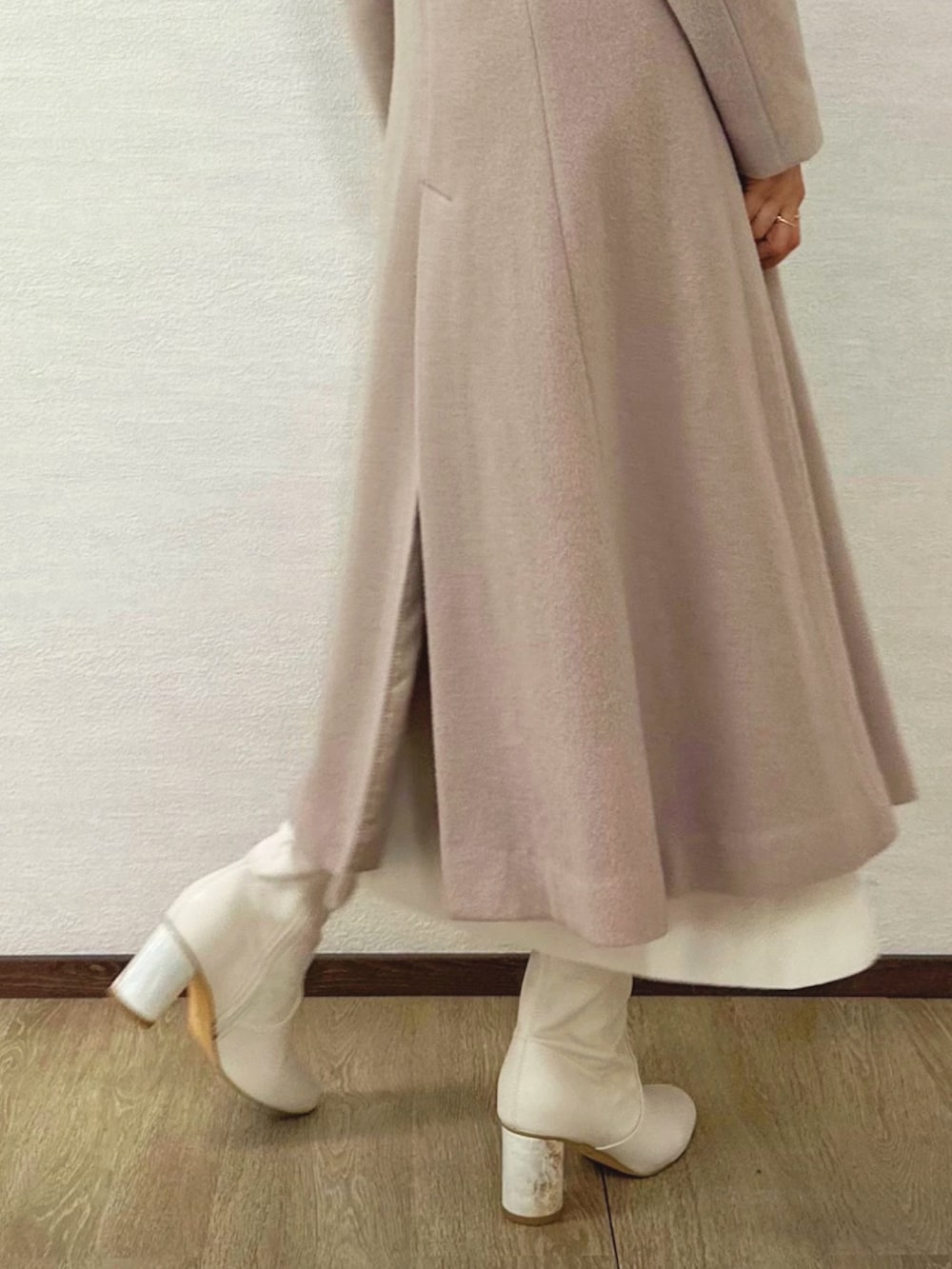 ホワイト系のブーツ、ベージュ系のその他アウター、ホワイト系のワンピースを着用したレディースの秋コーディネートの6枚目の写真