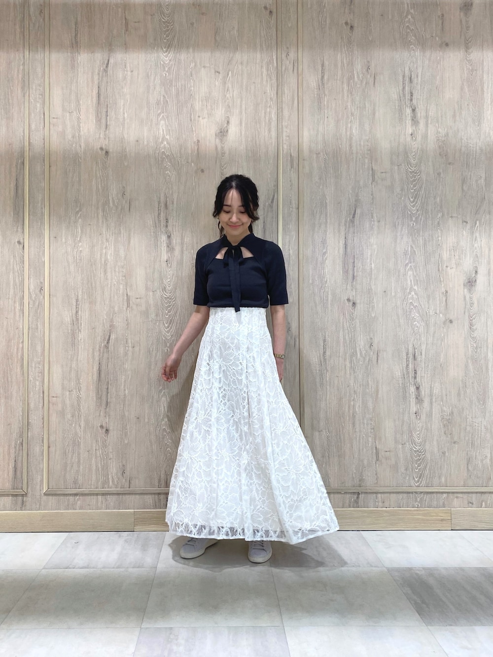 グレー系のスニーカー、ホワイト系のスカート、グレー系のニット/セーターを着用したレディースの冬コーディネートの3枚目の写真